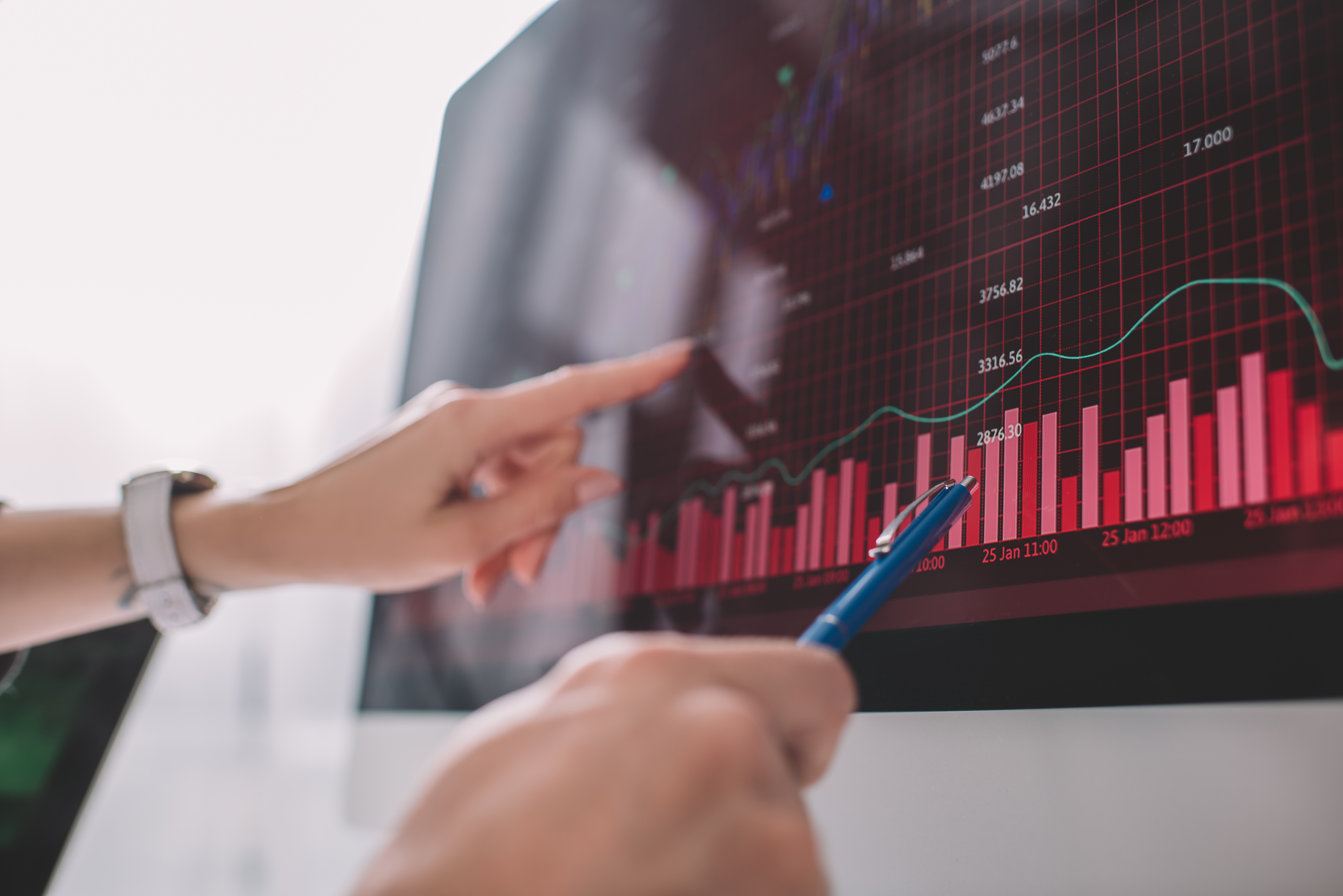 Selective focus of data analysts pointing on graphs on computer monitor while testing security of